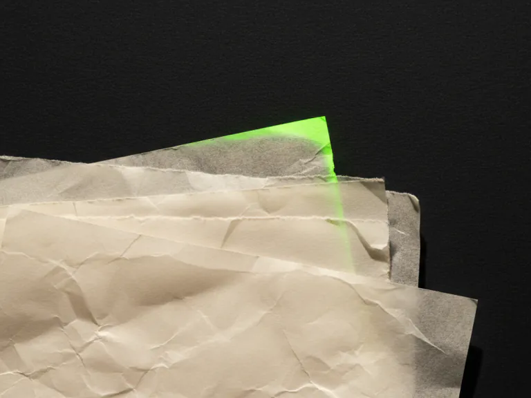 Gestapelte Papierbogen im Streiflicht